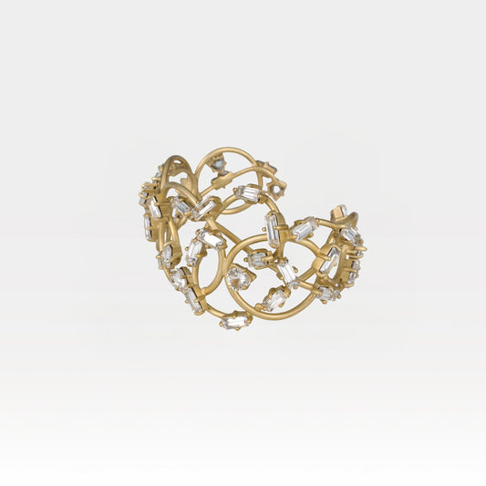Gold cuff with crystal embellishments on a light gray background