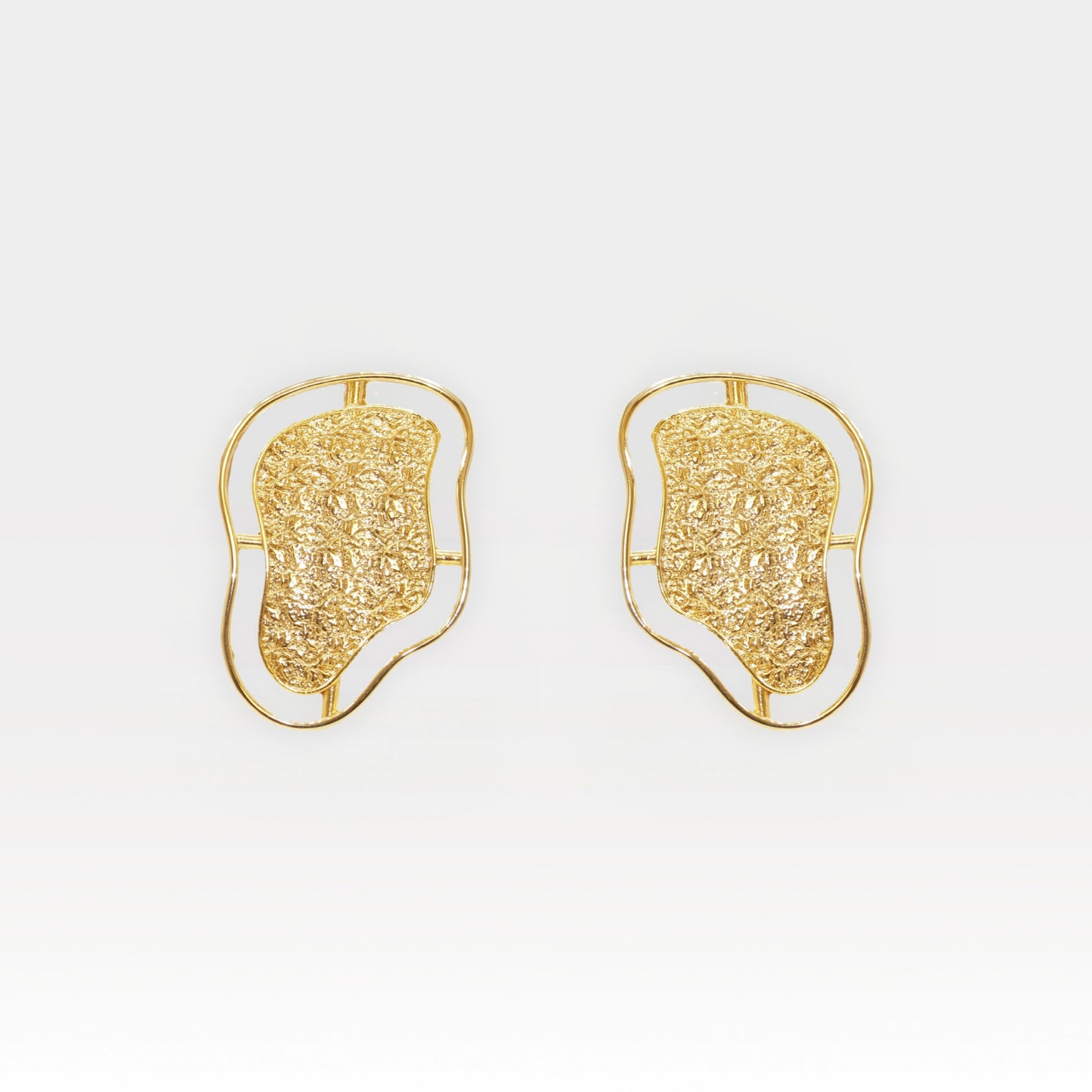 Pair of sculptural gold contour stud earrings with textured surface and fluid outline.