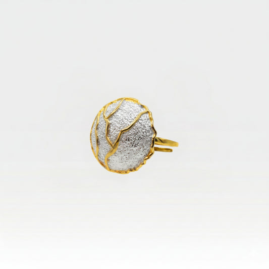 Kintsugi ring side view showing gold band and textured silver sphere with golden crack details