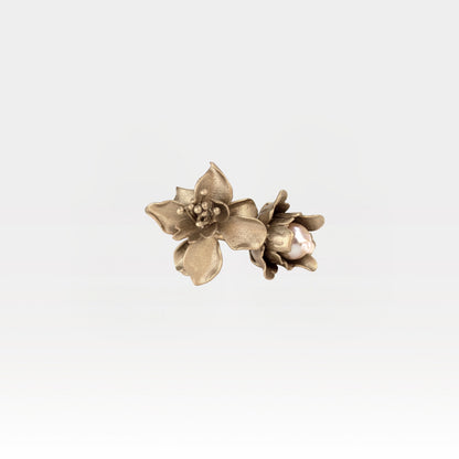 Pair of gold floral ring on a light gray background