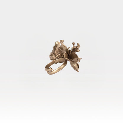 Bronze floral ring on a light gray background