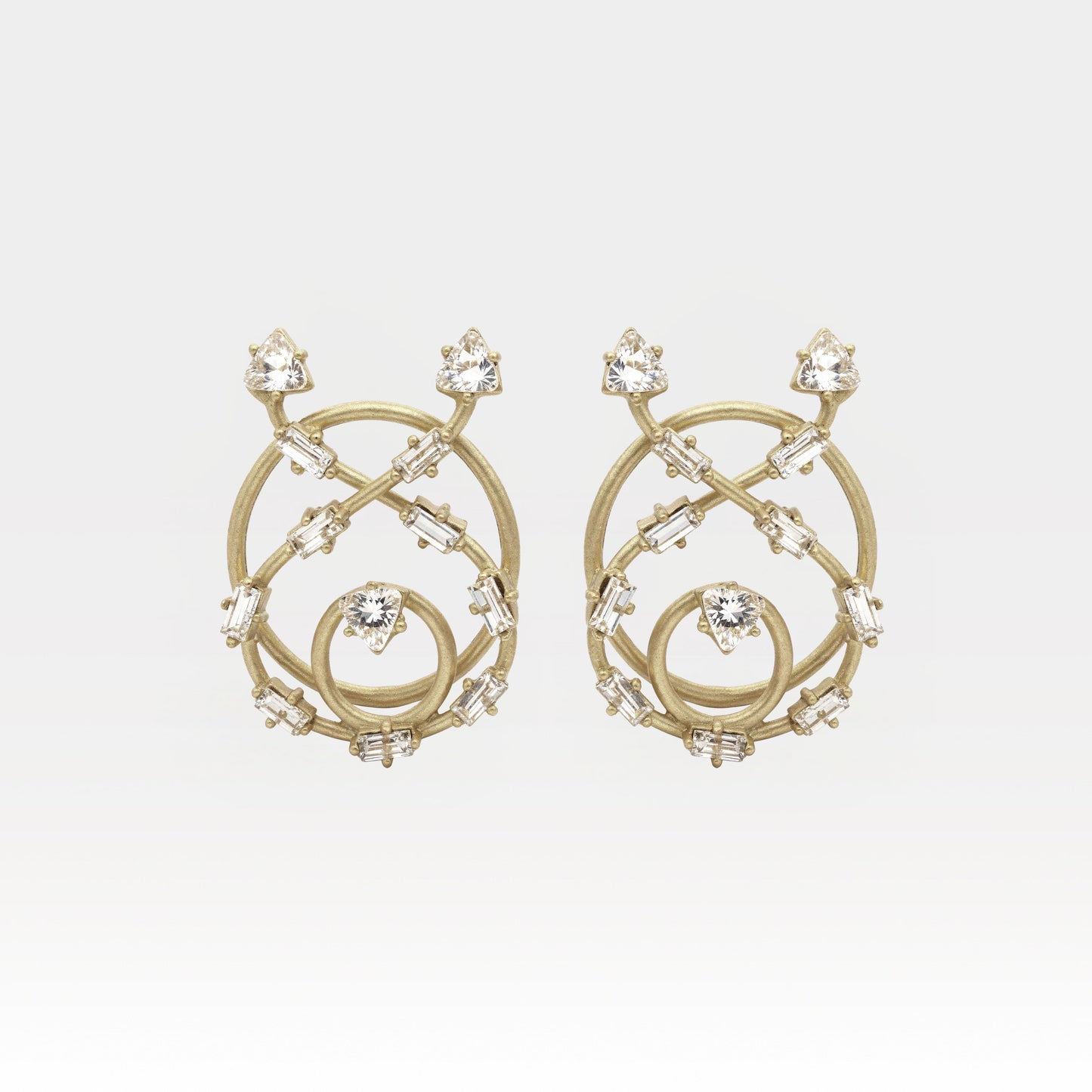 Gold earrings with intricate design and clear stones on a light gray background