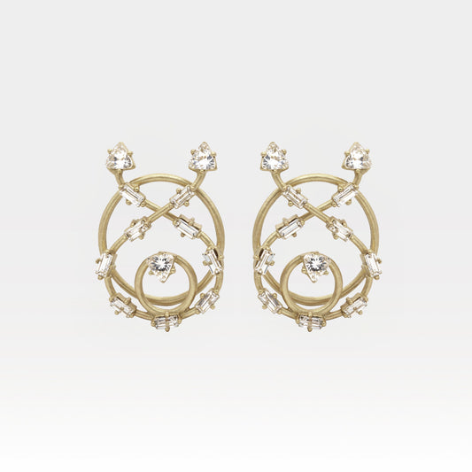 Gold earrings with intricate design and clear stones on a light gray background