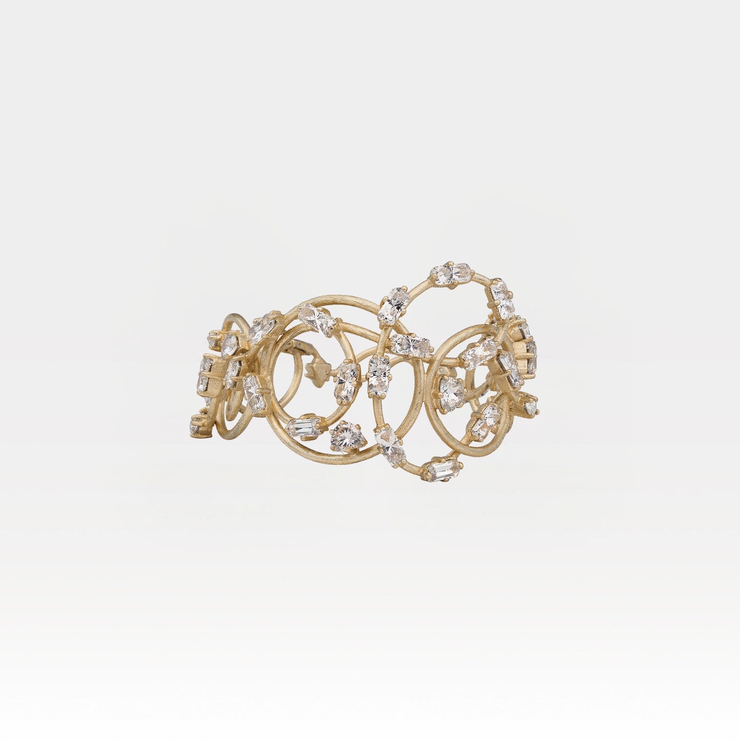 Gold bracelet with crystals on a light gray background