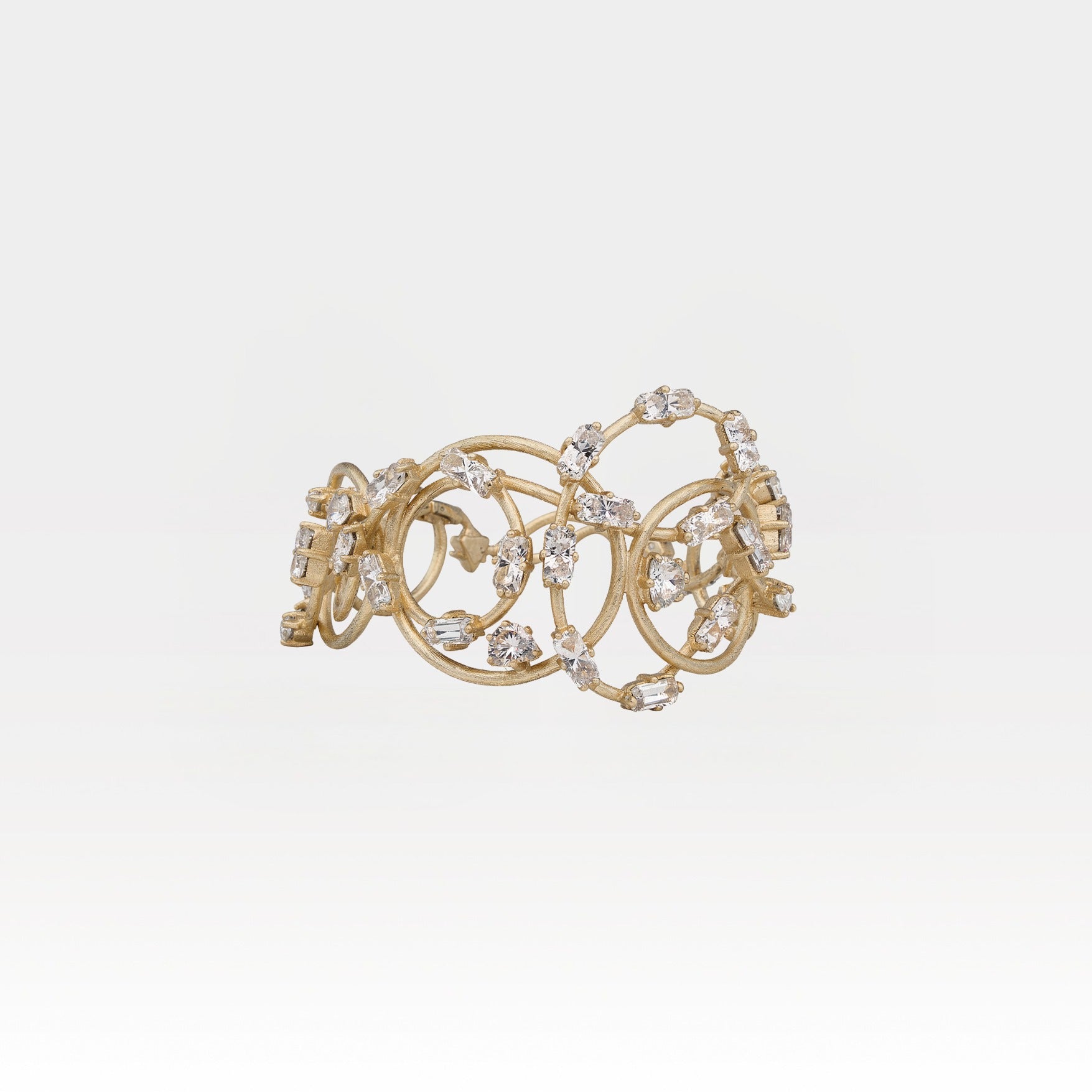 Gold bracelet with crystals on a light gray background