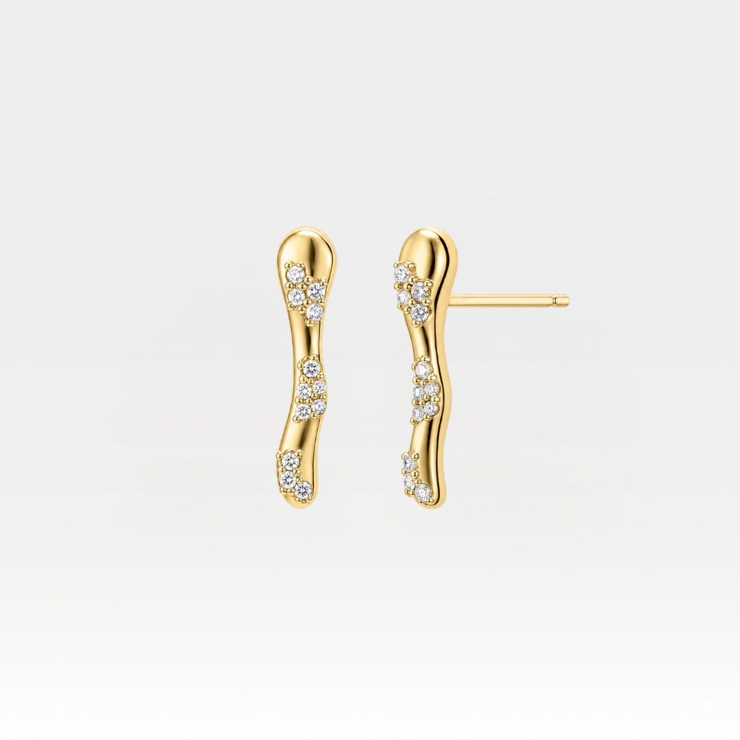 A pair of gold wavy bar stud earrings adorned with small clusters of clear pavé-set stones, shown against a clean white background.