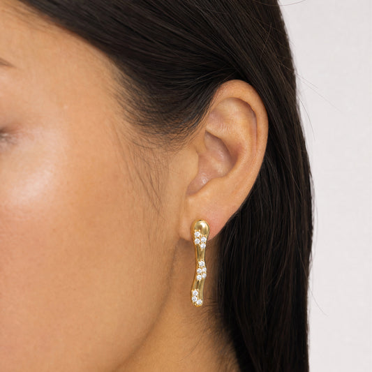 close up of a woman wearing gold earring with CZ