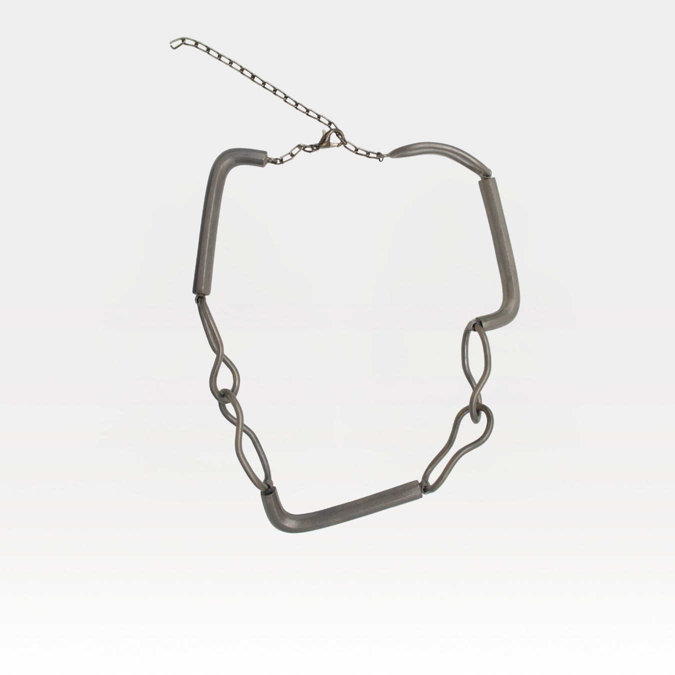 Silver chain necklace on a light gray background