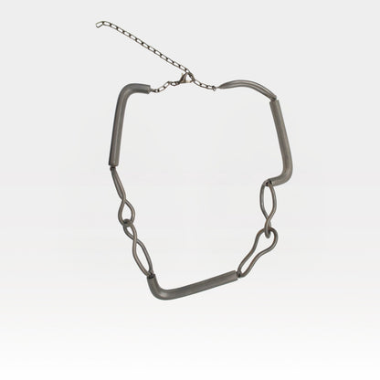 Silver chain necklace on a light gray background