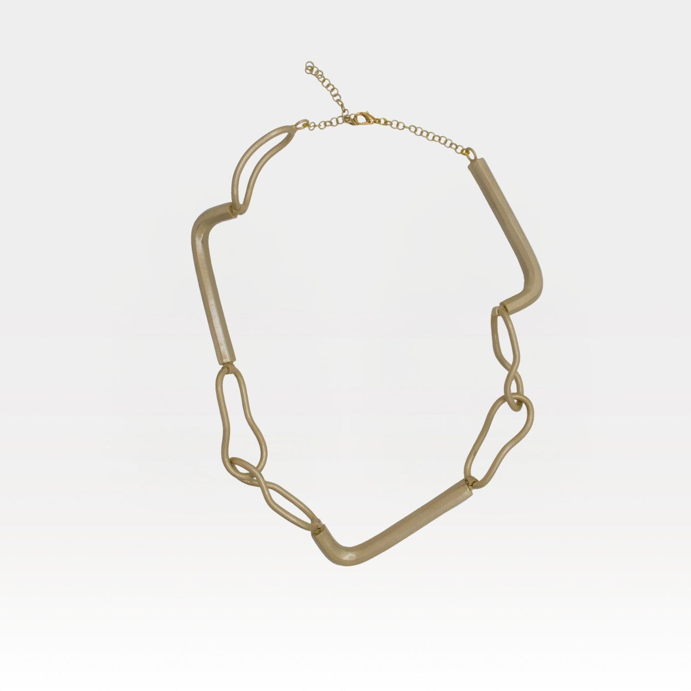 Gold chain necklace on a light gray background
