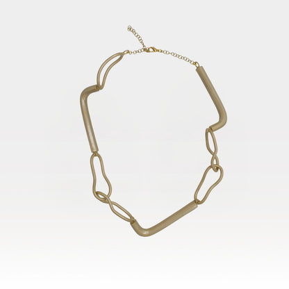 Gold chain necklace on a light gray background