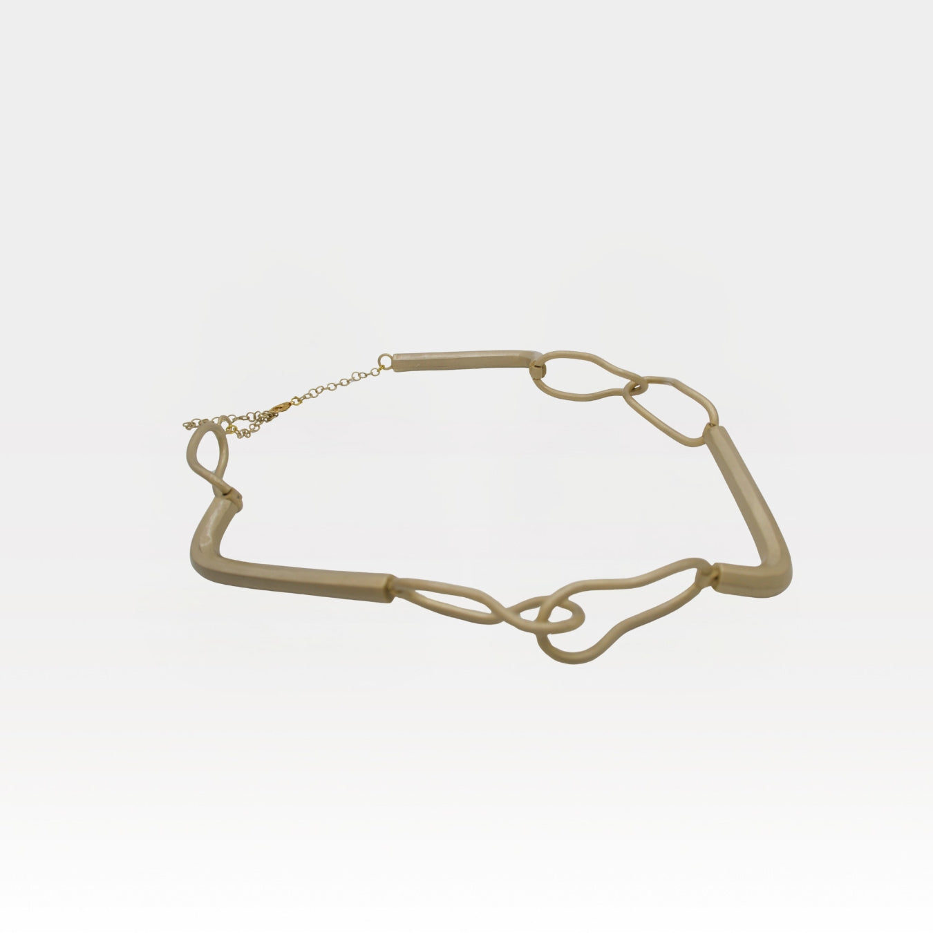 Gold chain necklace on a light gray background