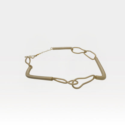 Gold chain necklace on a light gray background