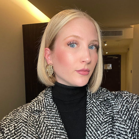 Close-up of a model wearing abstract gold contour earrings from the Contour Collection.