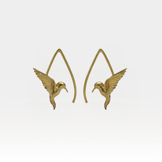Gold hummingbird earrings on a light gray background
