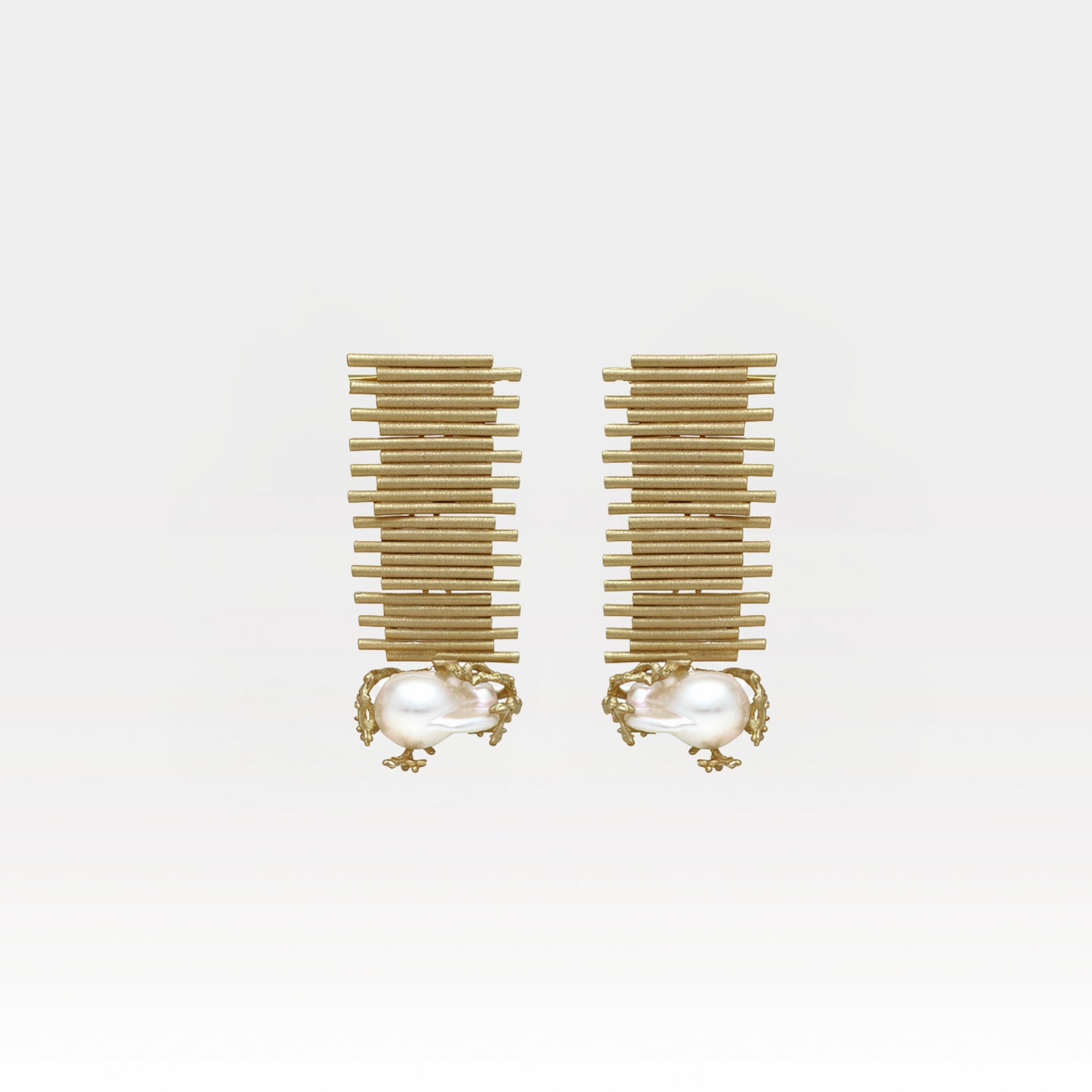 Pair of gold earrings with pearl-like centers on a white background