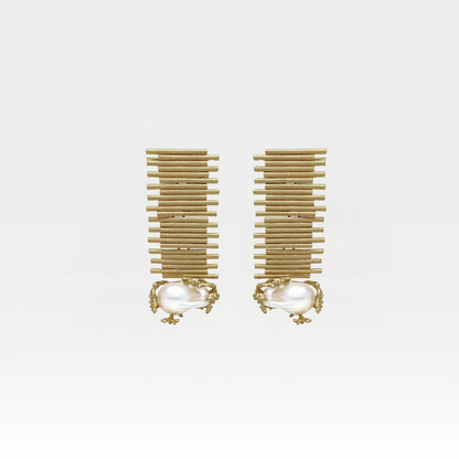 Pair of gold earrings with pearl-like centers on a white background