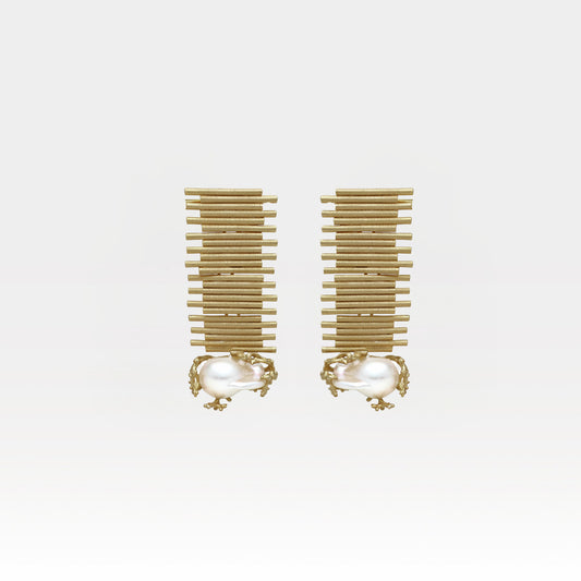 Pair of gold earrings with pearl-like centers on a white background