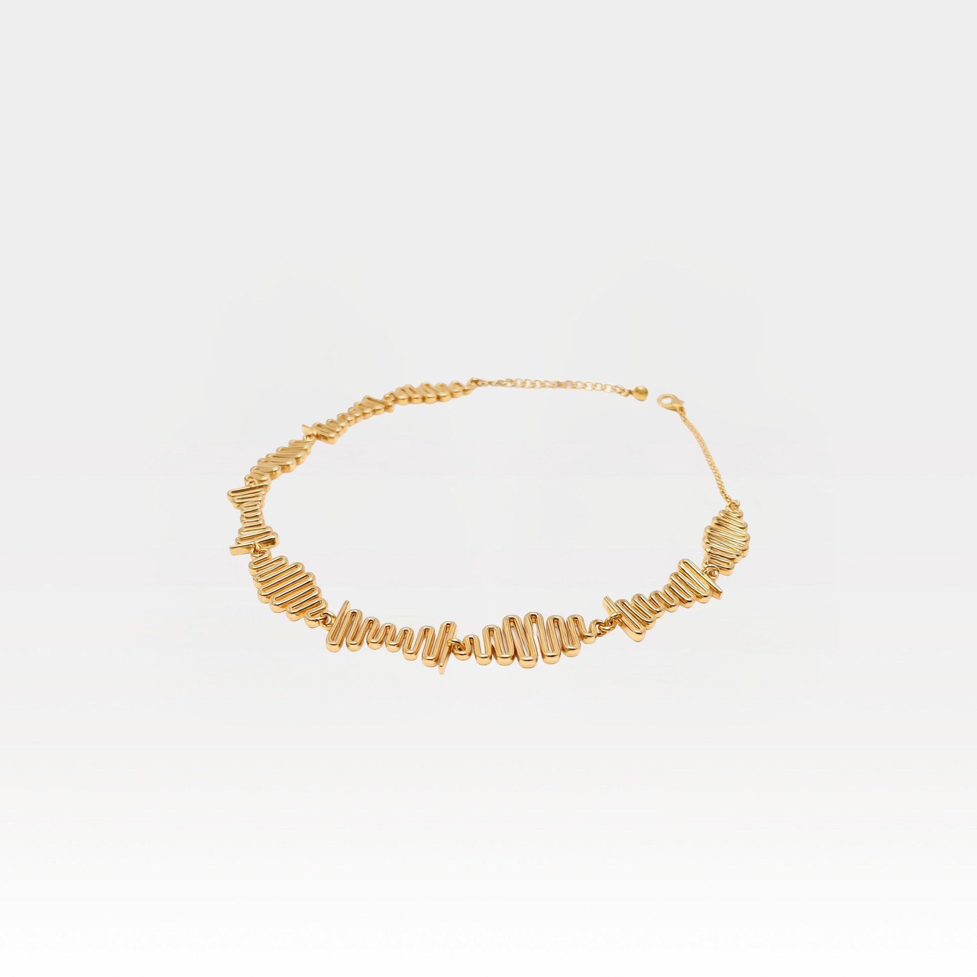 Gold necklace on a light gray background