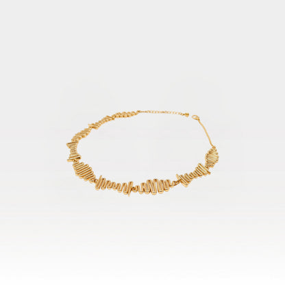 Gold necklace on a light gray background