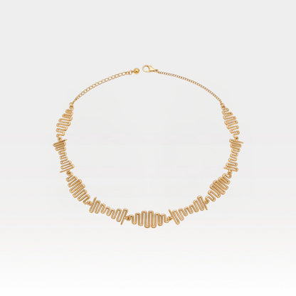 Gold necklace on a light gray background