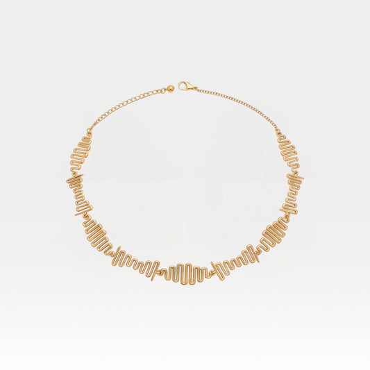 Gold necklace on a light gray background