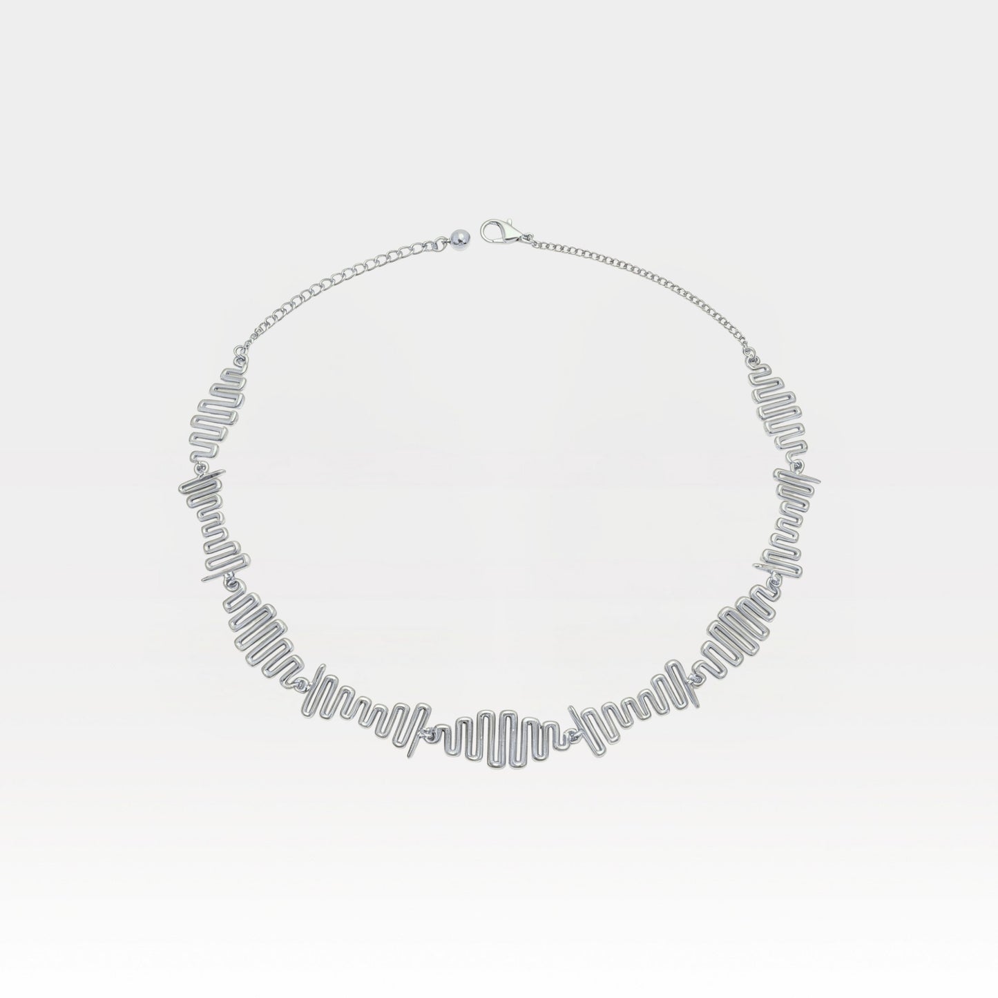 Silver necklace on a light gray background