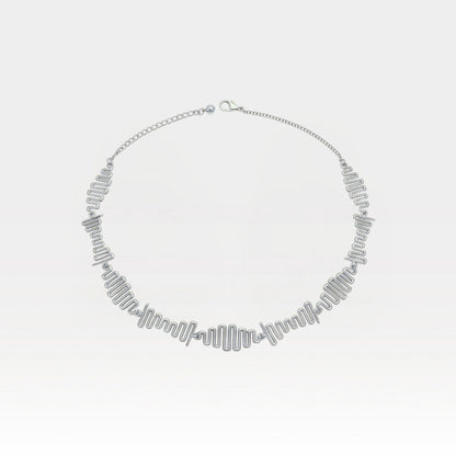 Silver necklace on a light gray background