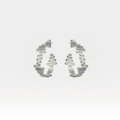 Silver hoop earrings on a light gray background