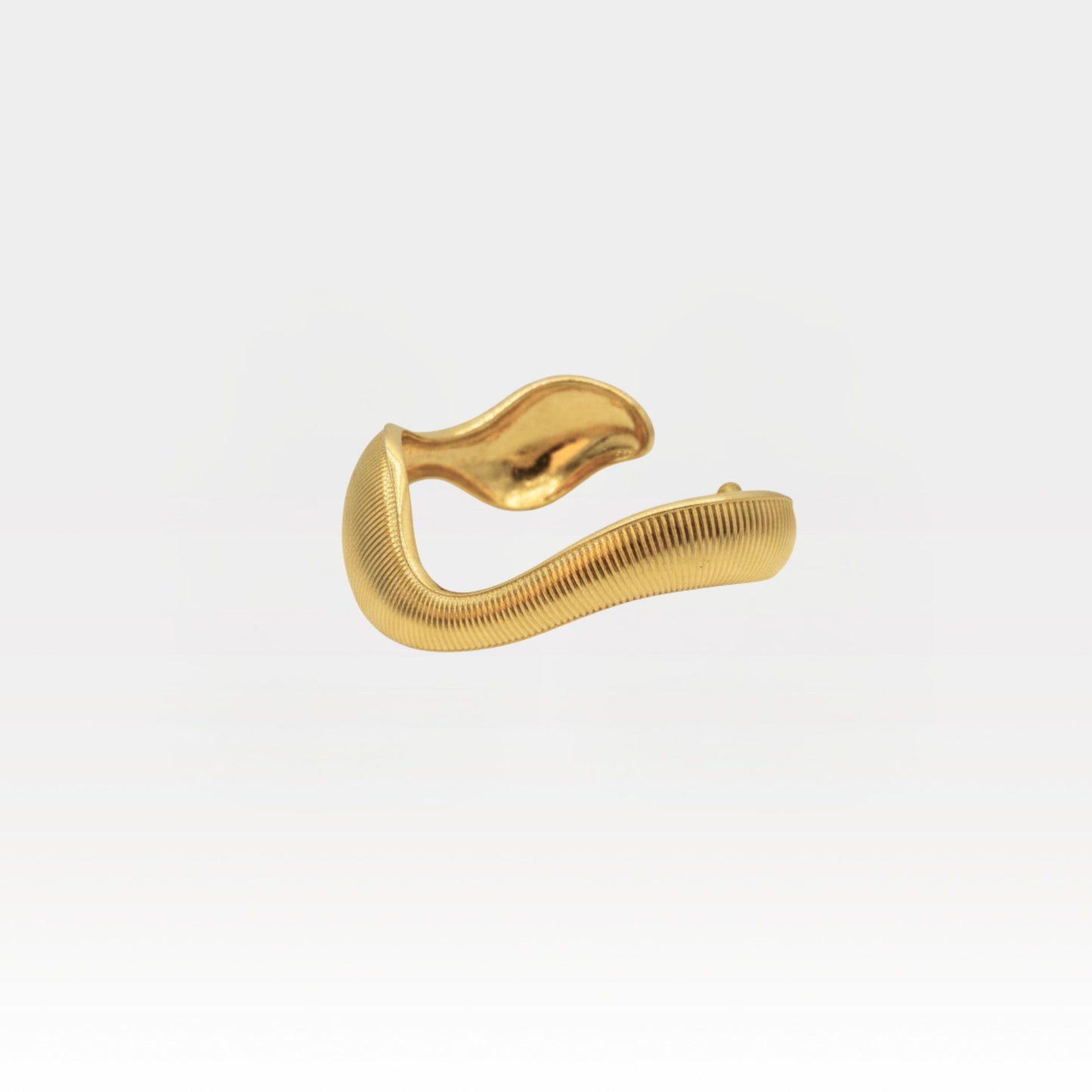 Sculptural 18k gold plated cuff bracelet with a wavy textured design on a light background