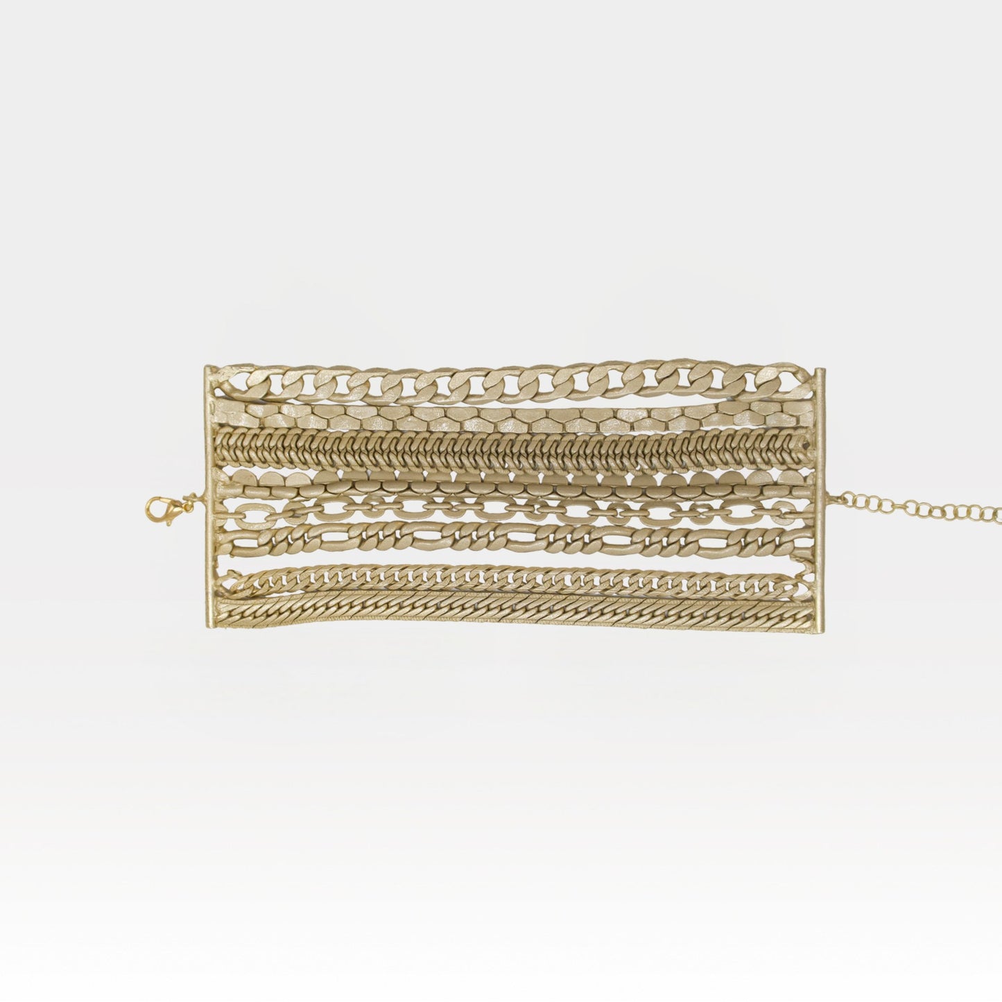 Gold bracelet with various links on a white background