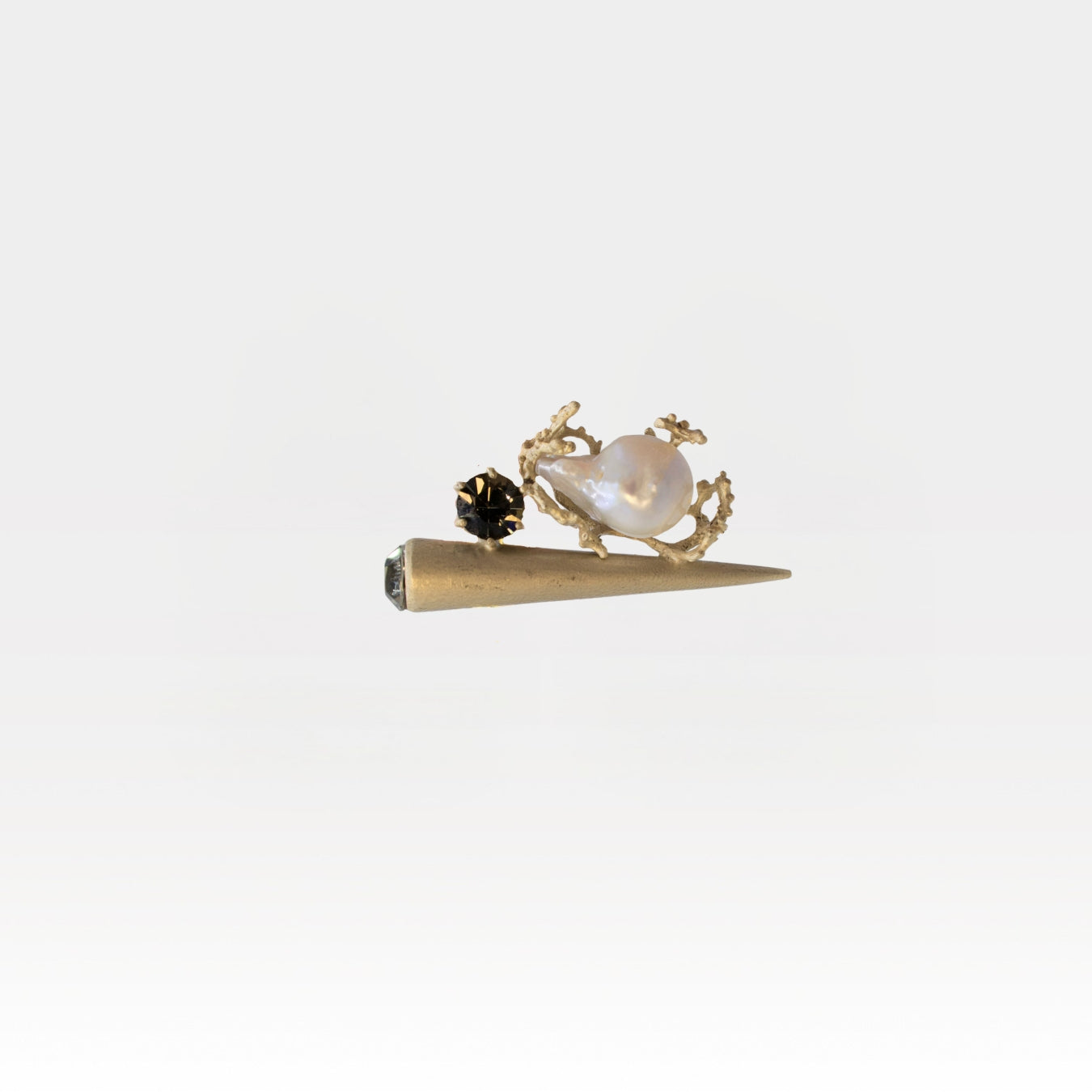 Gold cone-shaped ring with pearl and crystals on a white background