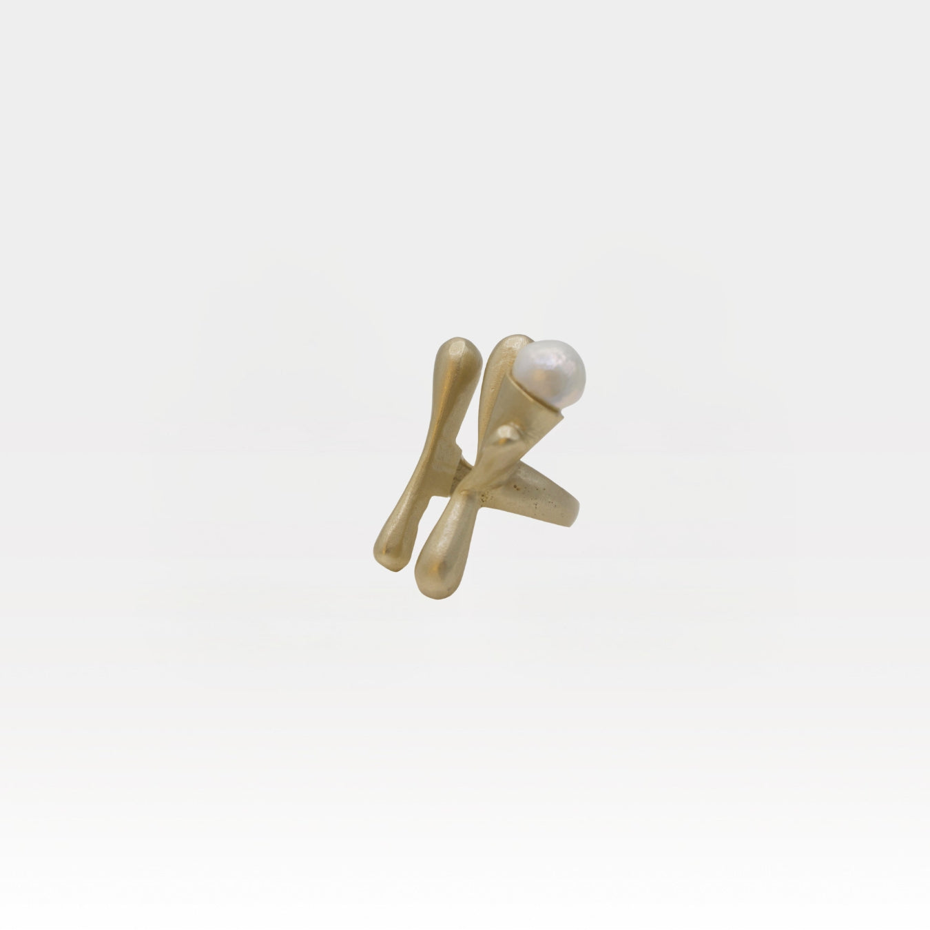 Gold ring with a pearl on a white background