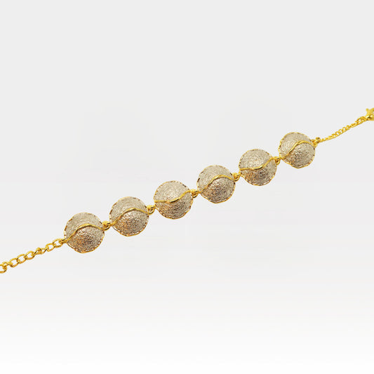 Kintsugi bracelet close-up showing textured gold spheres connected by chain, Japanese-inspired jewelry detail