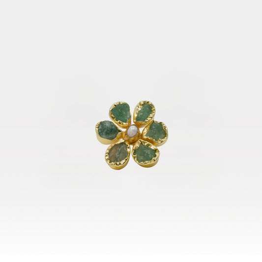 Gold flower-shaped ring with green gemstones on a white background