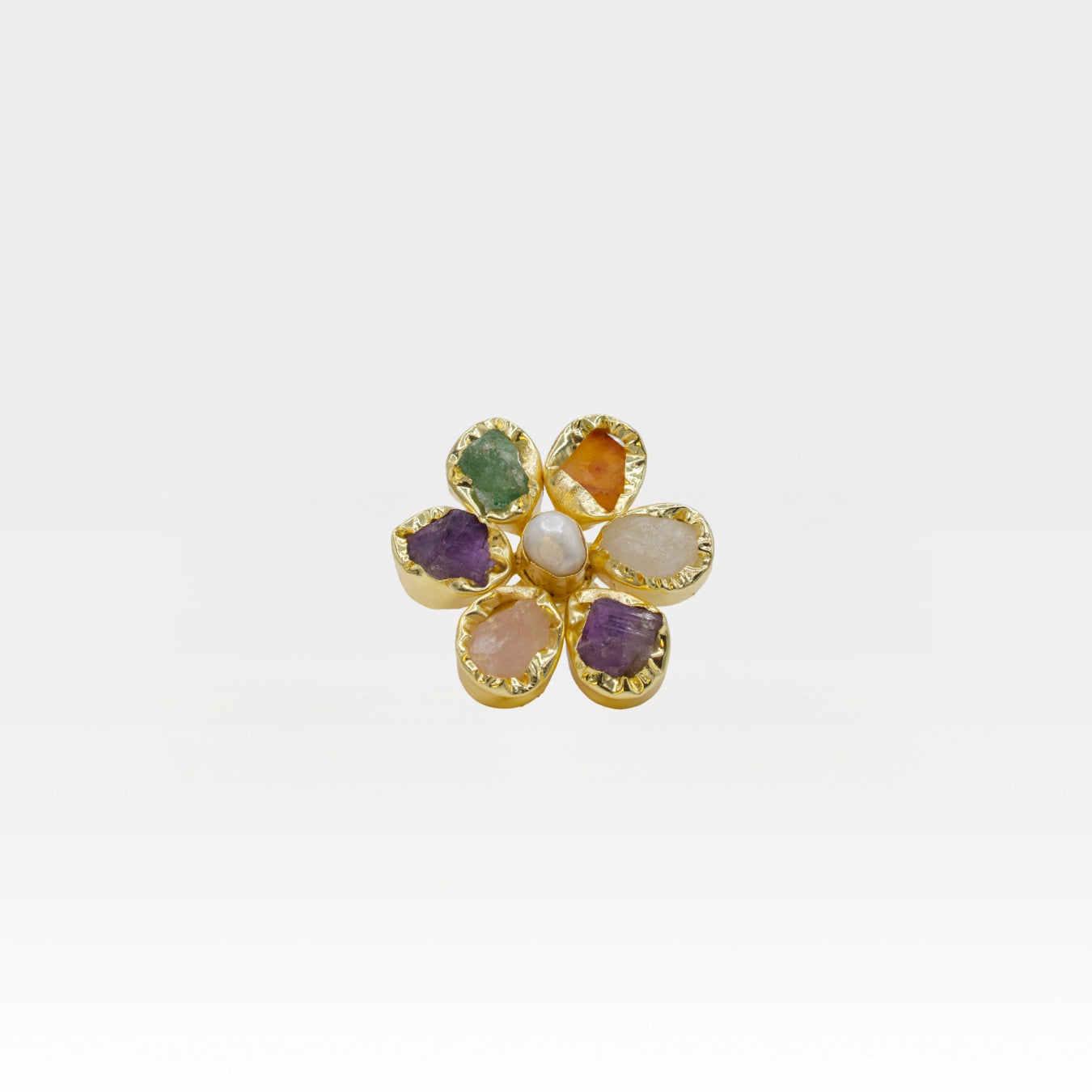 Gold flower-shaped ring with multicolored stones on a white background