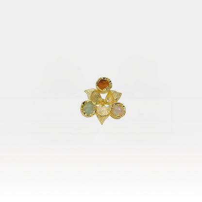 Gold flower-shaped ring with gemstones on a white background