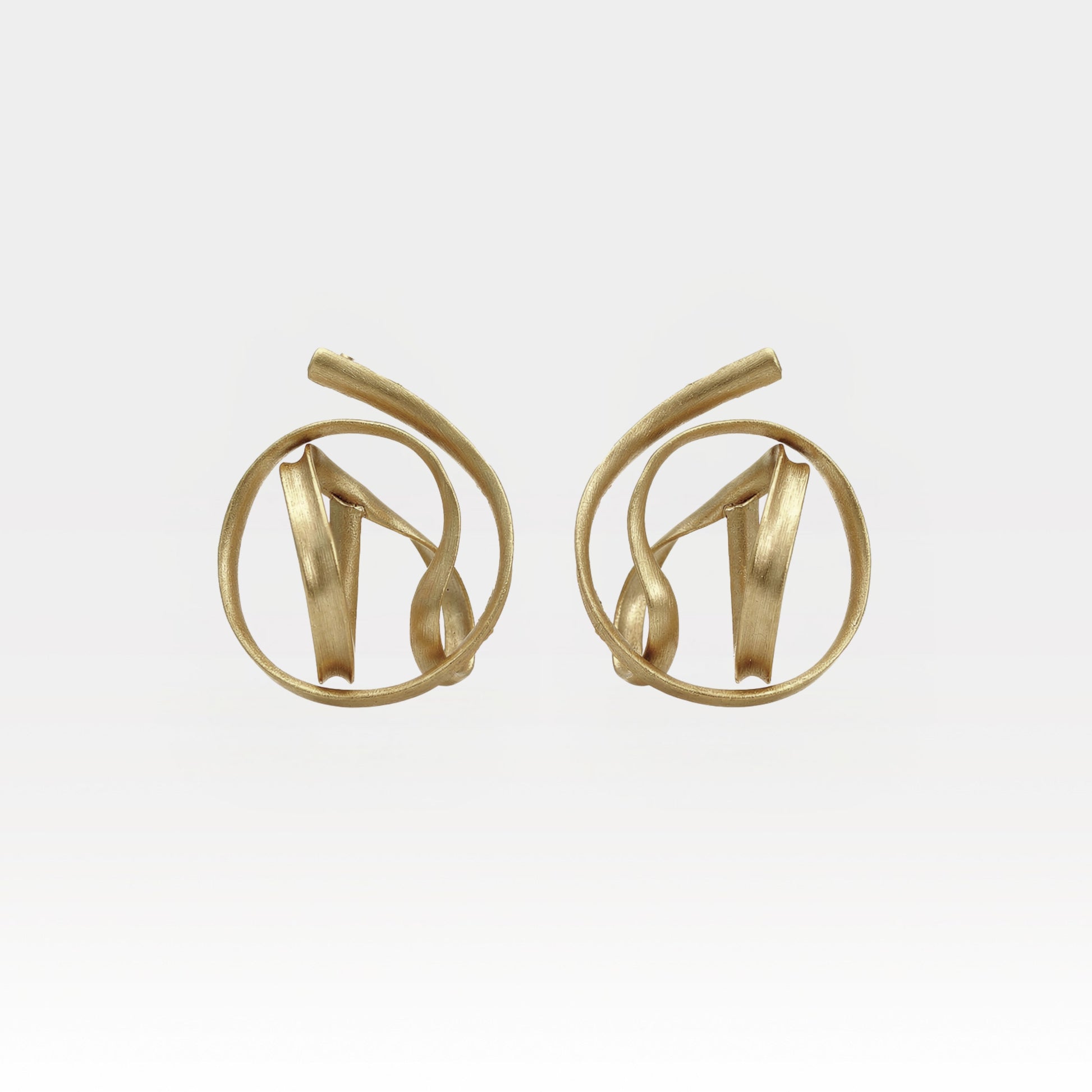 Pair of gold earrings on a light gray background