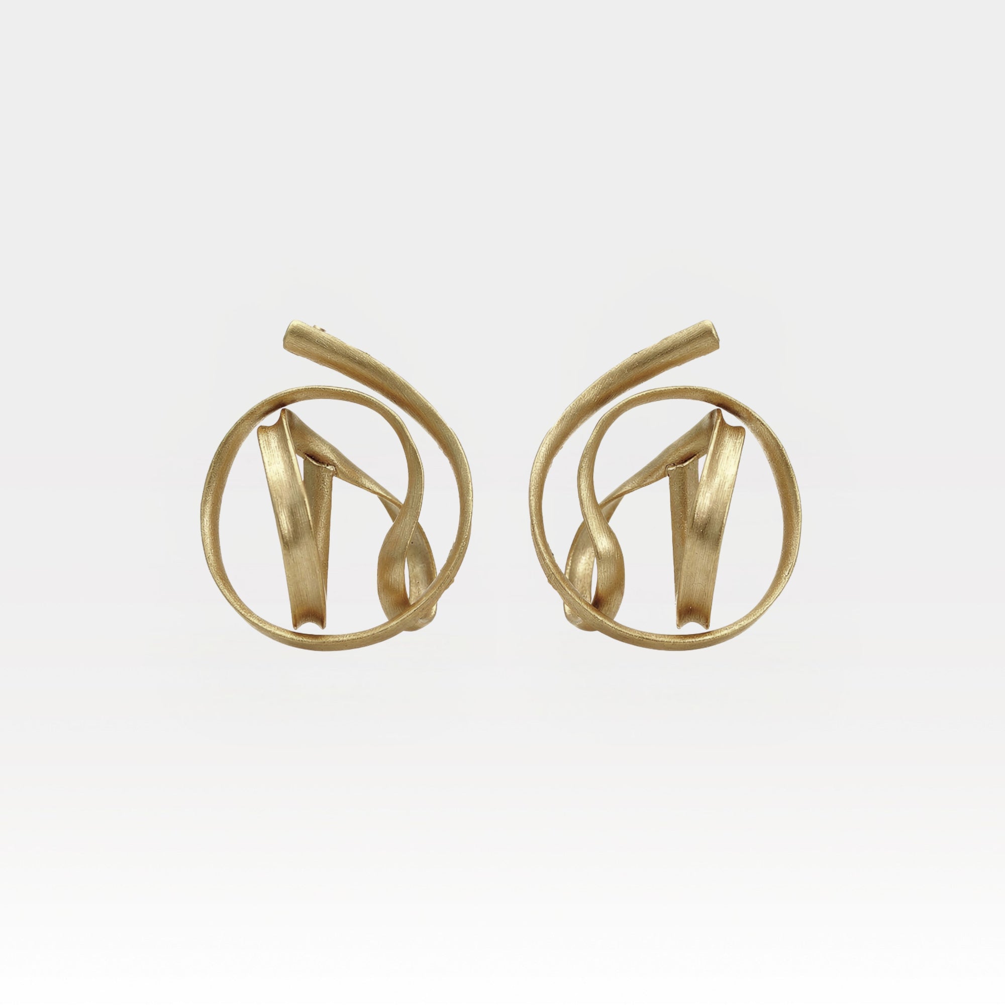 Pair of gold earrings on a light gray background