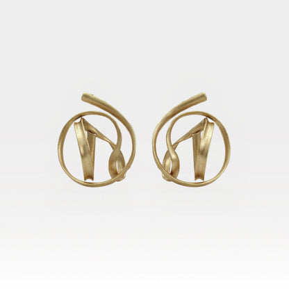 Pair of gold earrings on a light gray background