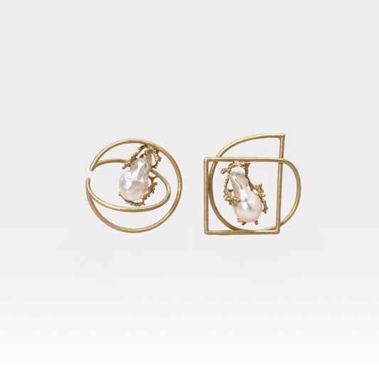 Pair of gold earrings with pearl-like stones on a light gray background