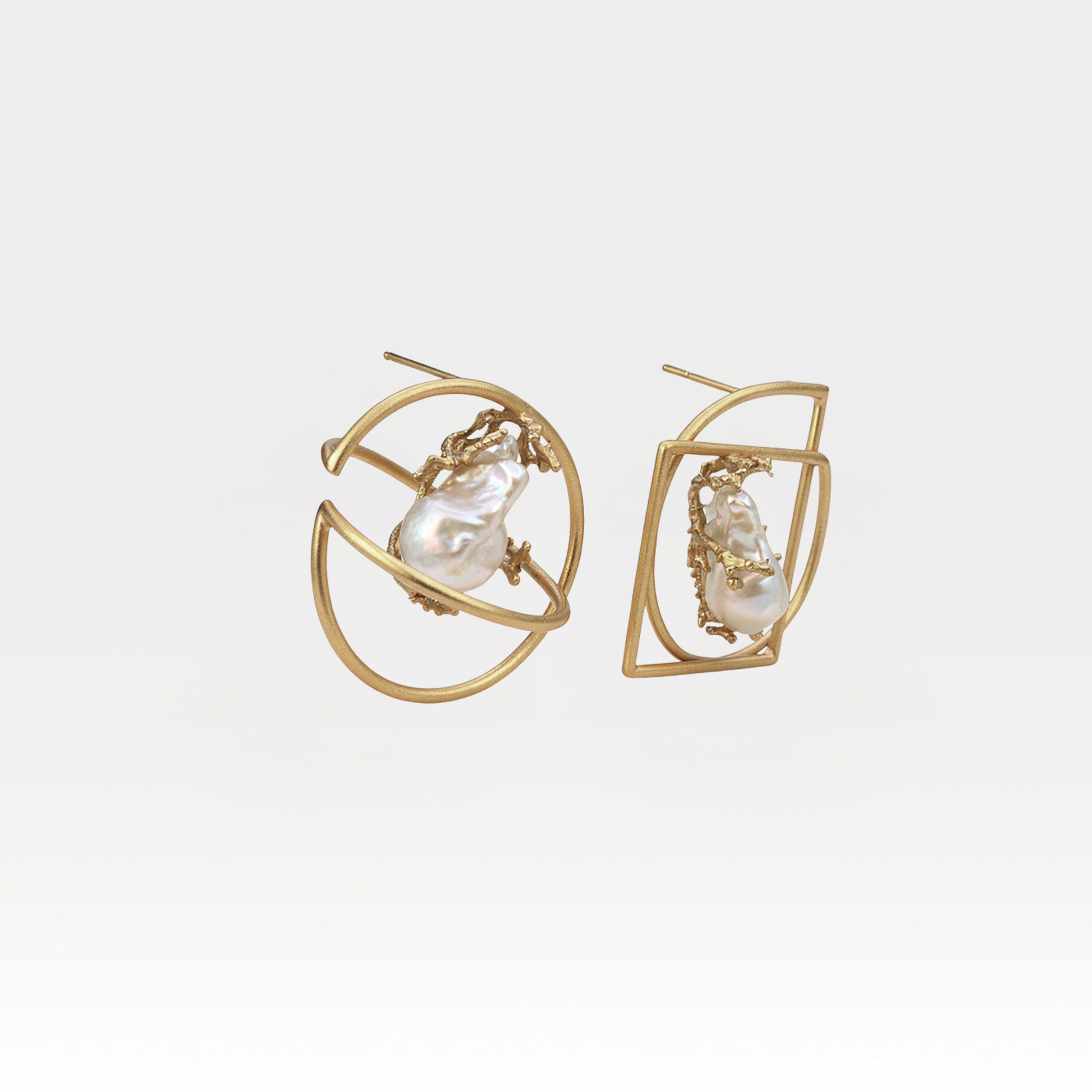 Pair of gold earrings with pearl-like centers on a light gray background