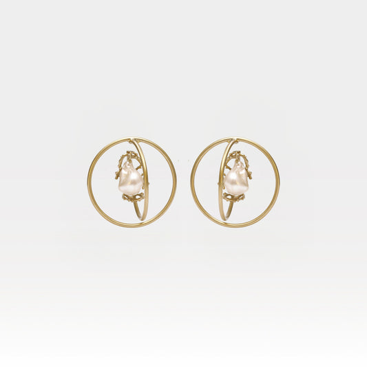 Gold hoop earrings with pearl center on a light gray background